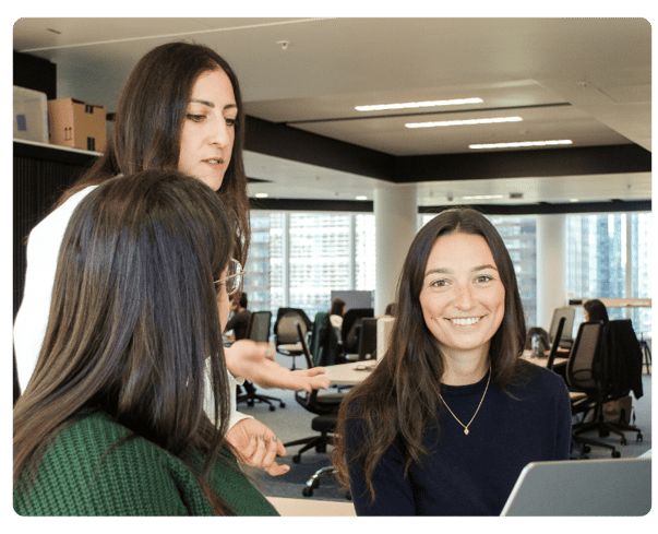 Three women in a UK office working together on an expense management solution.
