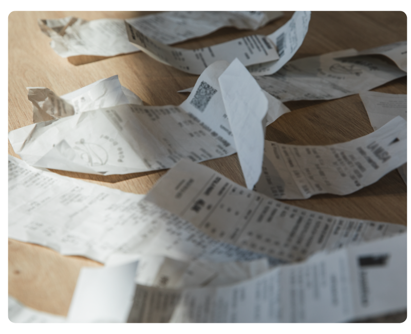 Papierbelege auf einem Tisch – Symbol für papierbasierte Reisekostenabrechnung vor der Digitalisierung durch Mobilexpense
