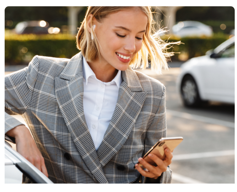 Mitarbeiterin prüft Reisekosten auf dem Smartphone unterwegs, mobile Reisekostenabrechnung und digitales Spesenmanagement im Arbeitsalltag.