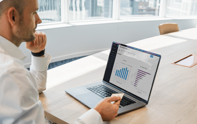 Man looking at analytics on screen holding a credit card.
